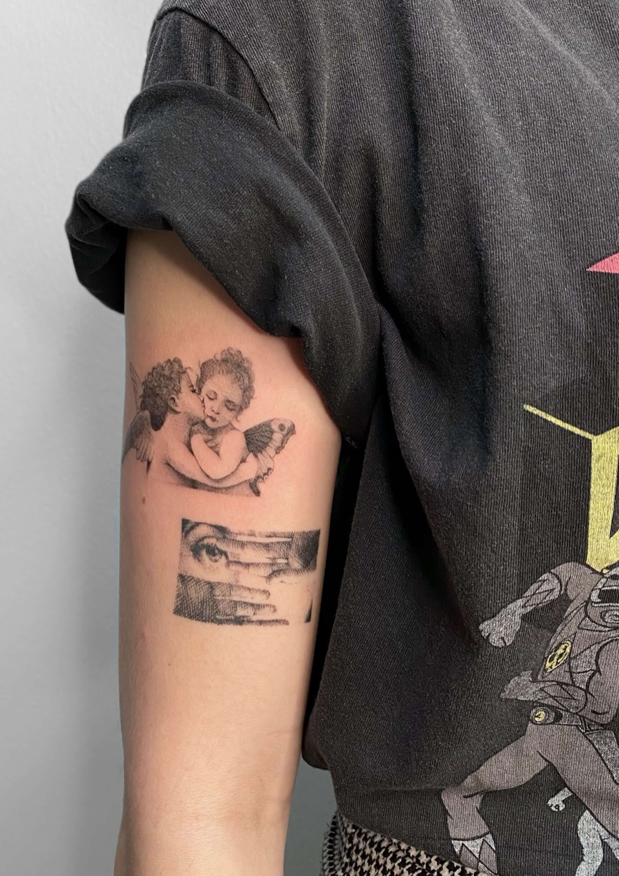 Fine line cherub angels tattoo with engraving-style eye and hand on upper arm by Irka in Helsinki