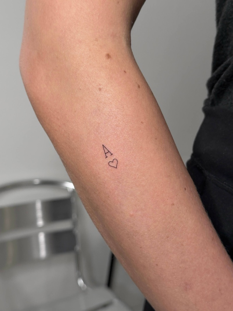 Micro letter A with heart tattoo on forearm by Irka in Helsinki