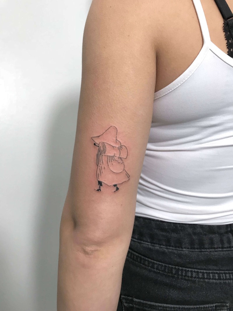 Snufkin Moomin character tattoo on upper arm by Irka in Helsinki