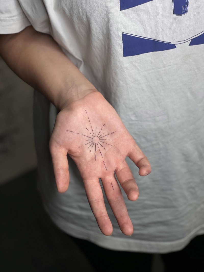 Geometric sunburst palm tattoo by Irka in Helsinki