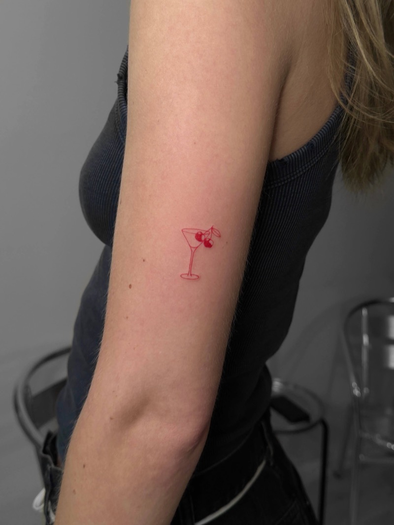 Red ink martini cocktail glass tattoo on inner arm by Irka in Helsinki