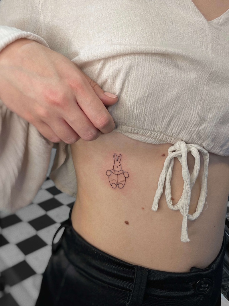Cute bunny toy tattoo on ribs by Irka in Helsinki